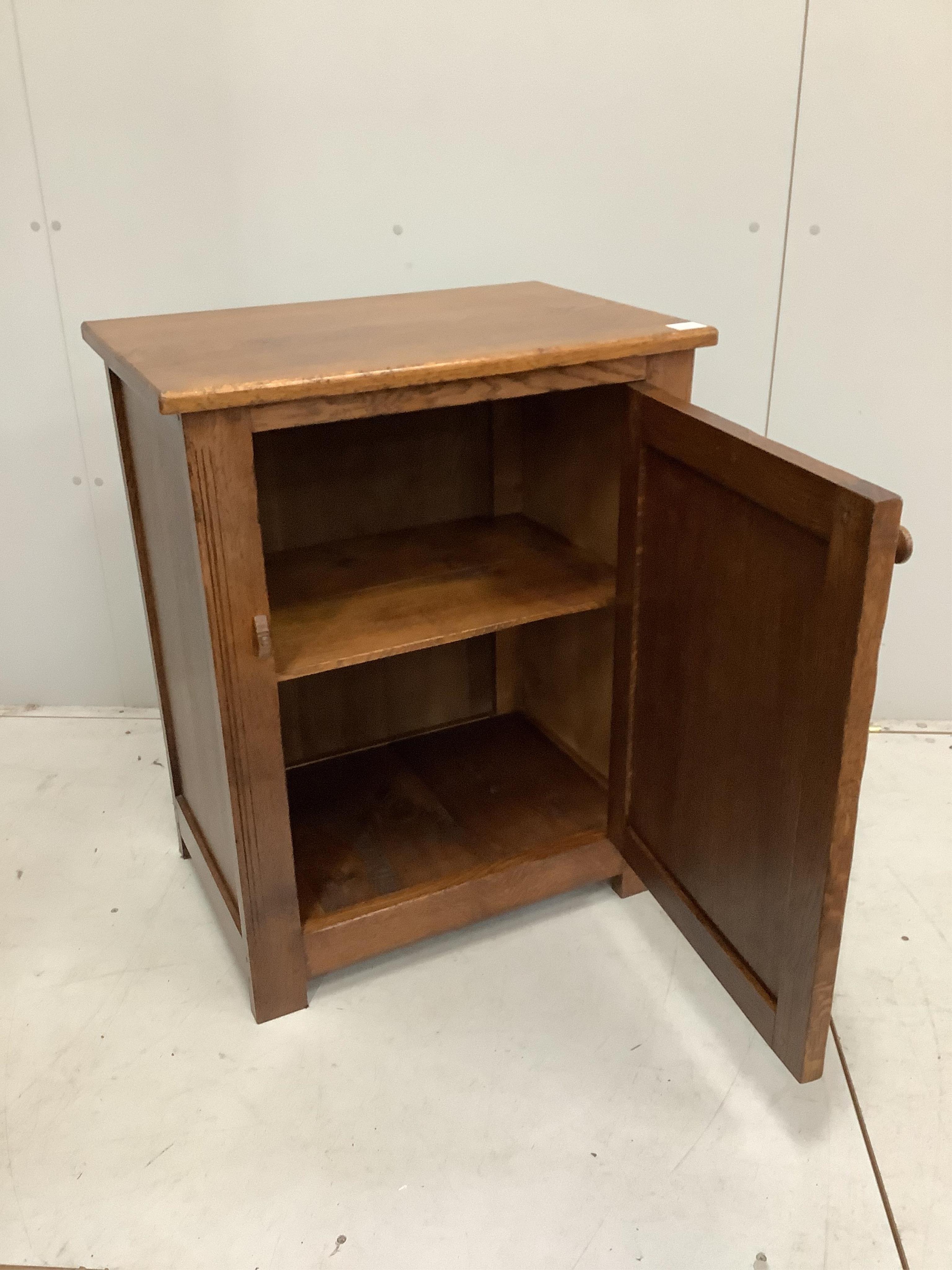 A near Contemporary oak cupboard, enclosed by a panelled door, width 68cm, height 84cm. Condition - light scuffs, otherwise good